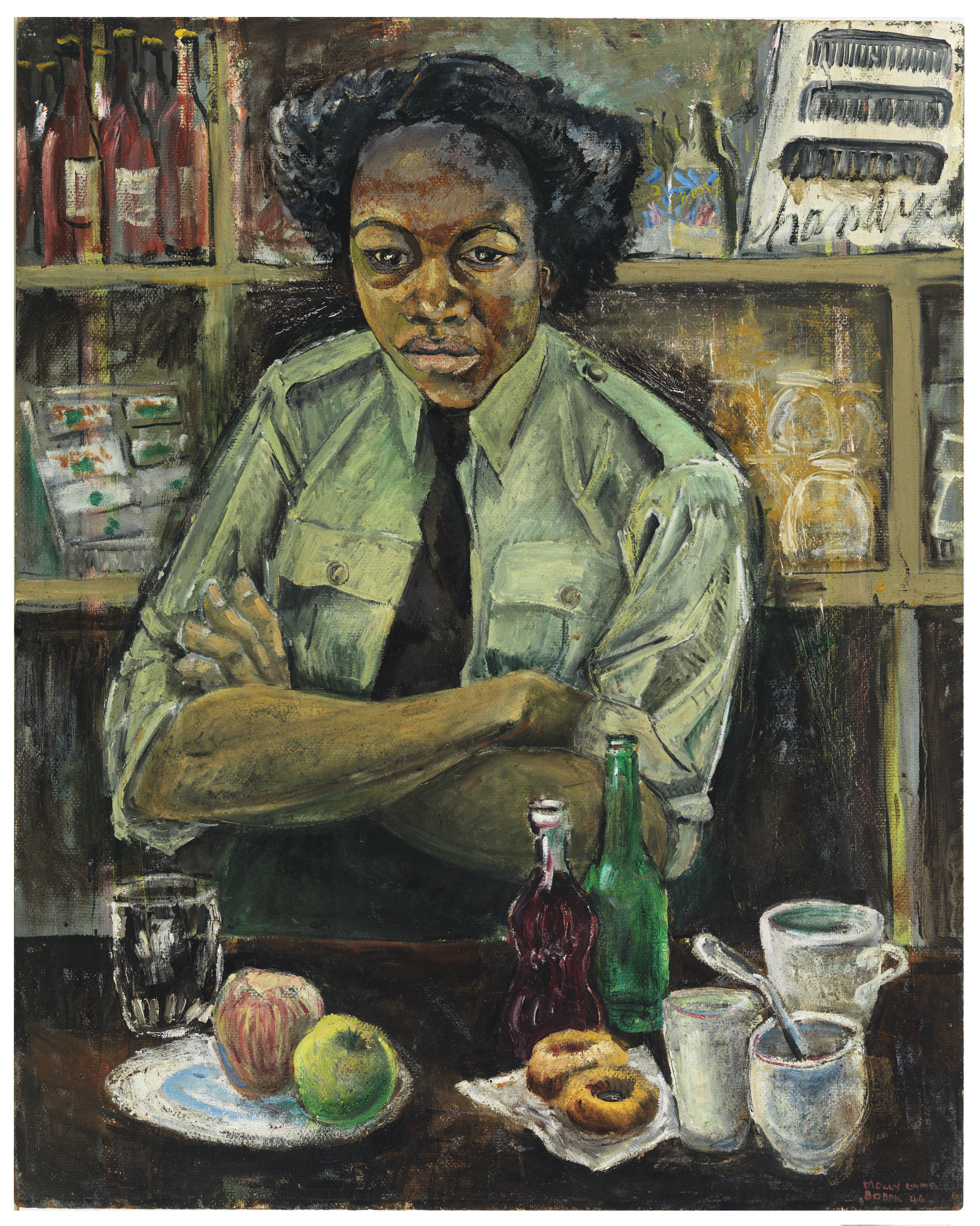 A woman in military uniform sitting at a café counter with folded arms. Bottles and dishes fill the background while fruit, cups and a doughnut sit on the counter in front of her.