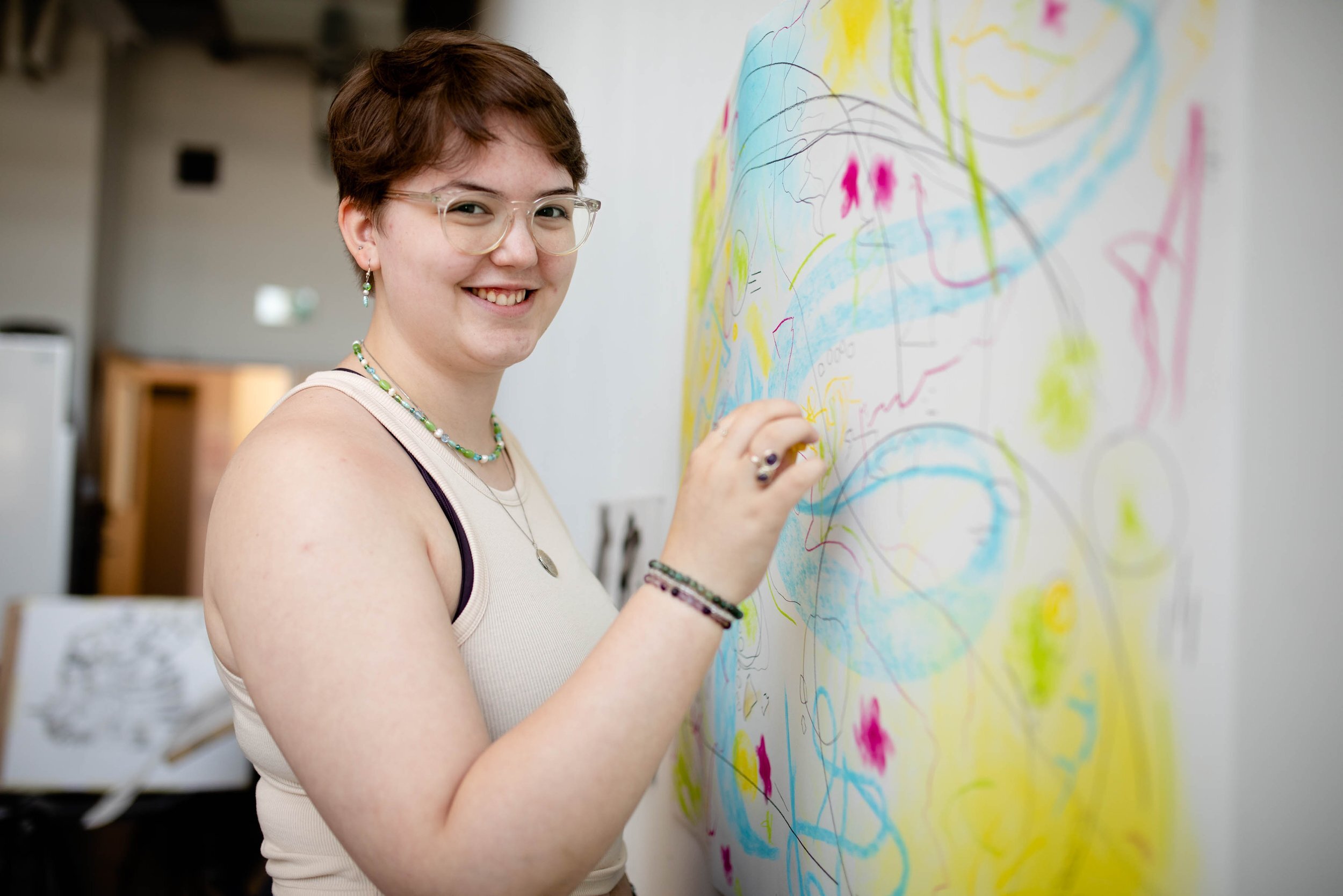 student smiling at the camera drawing