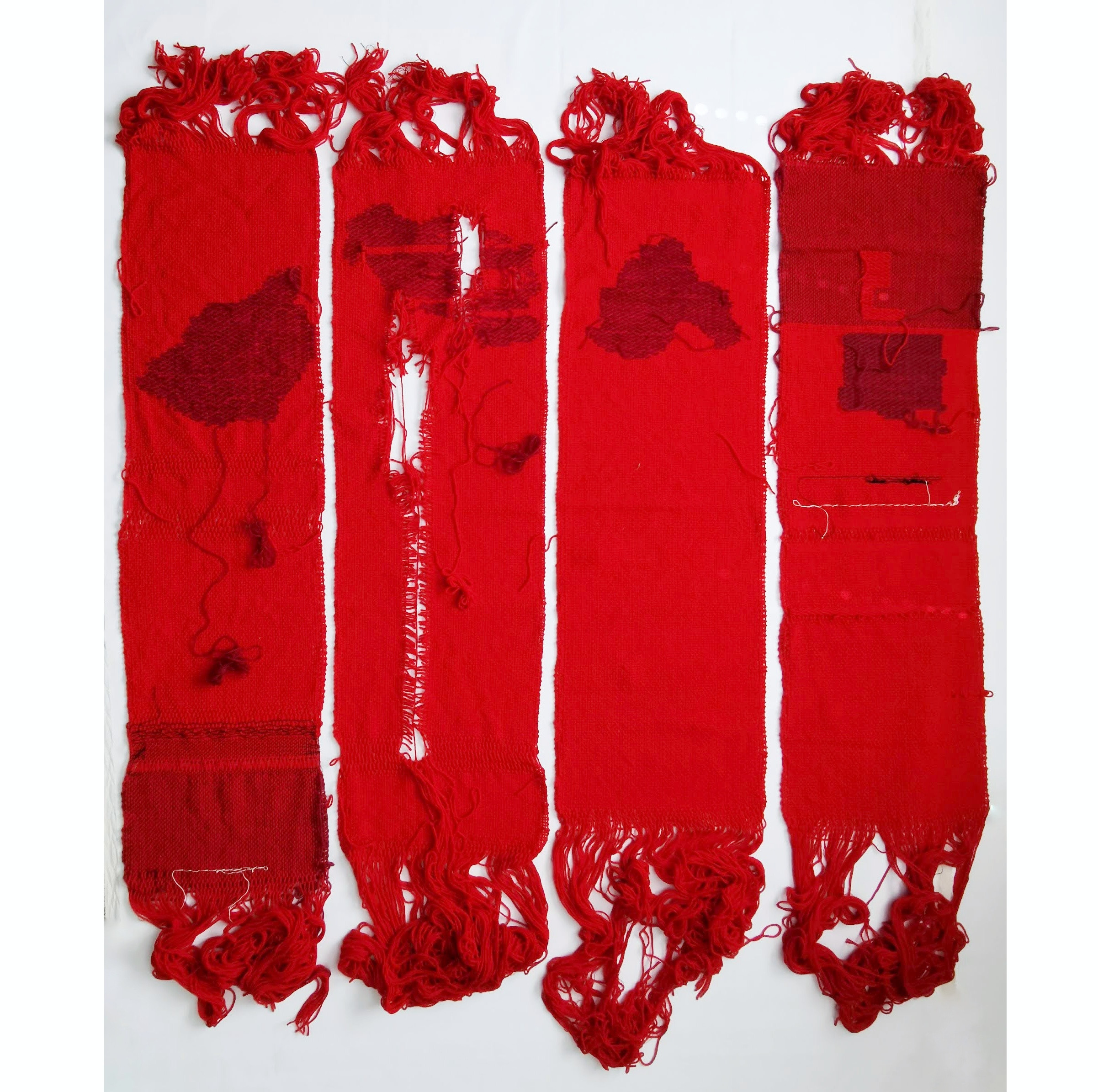 An artwork with four red fabrics in strips next to each with some fraying in the middle