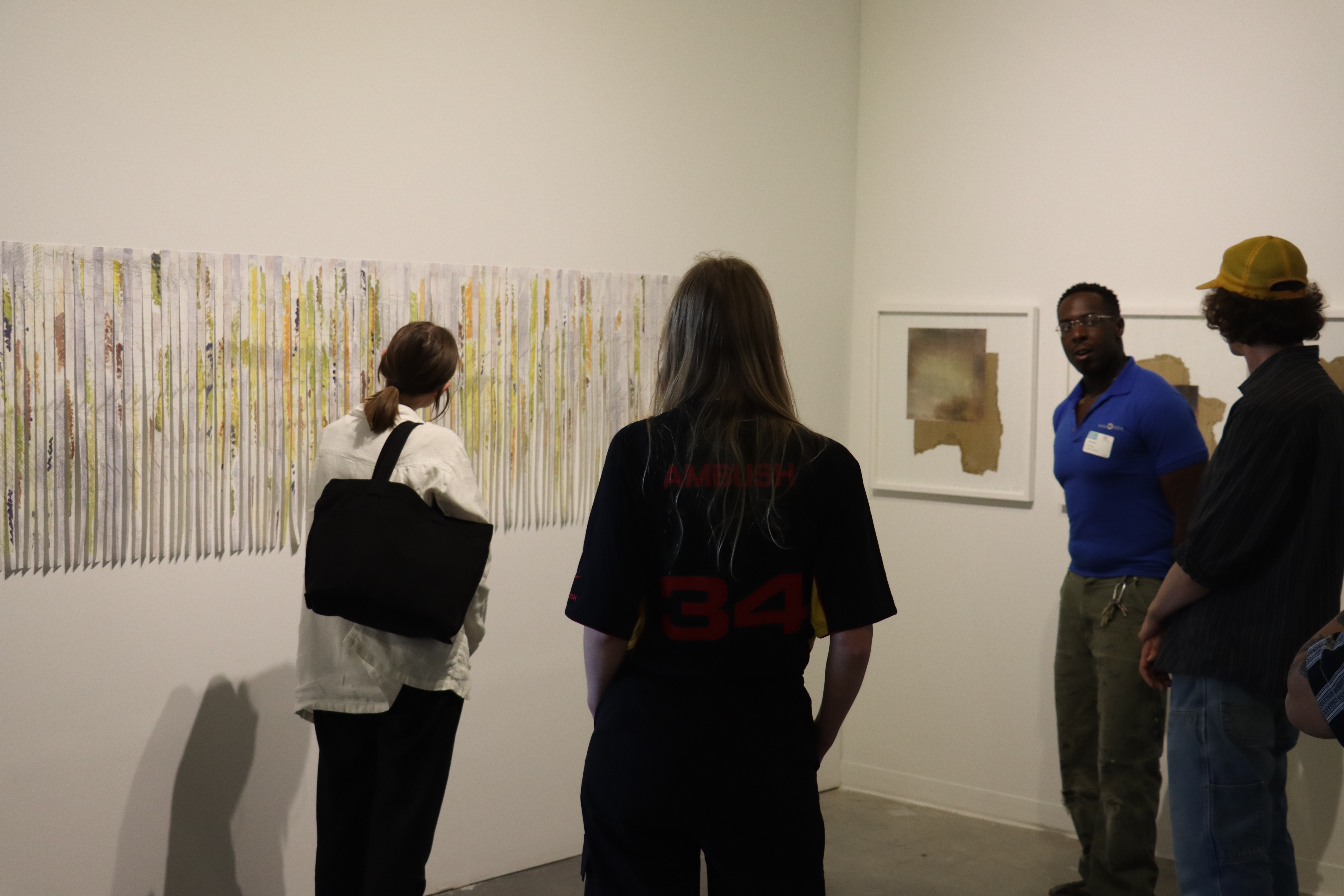 Four people in discussion in front of an artwork