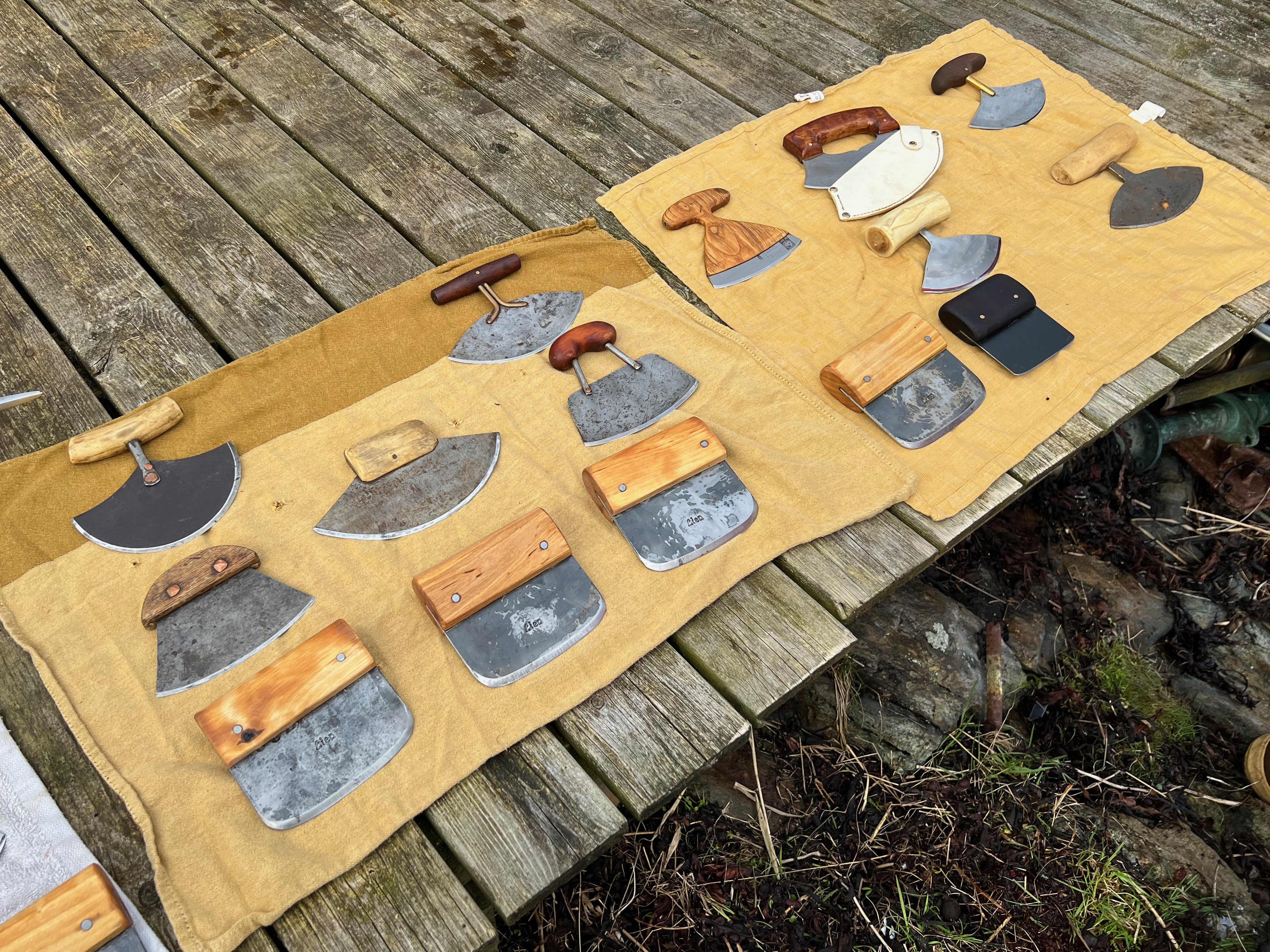 A tan spread with many different types of ulu knives
