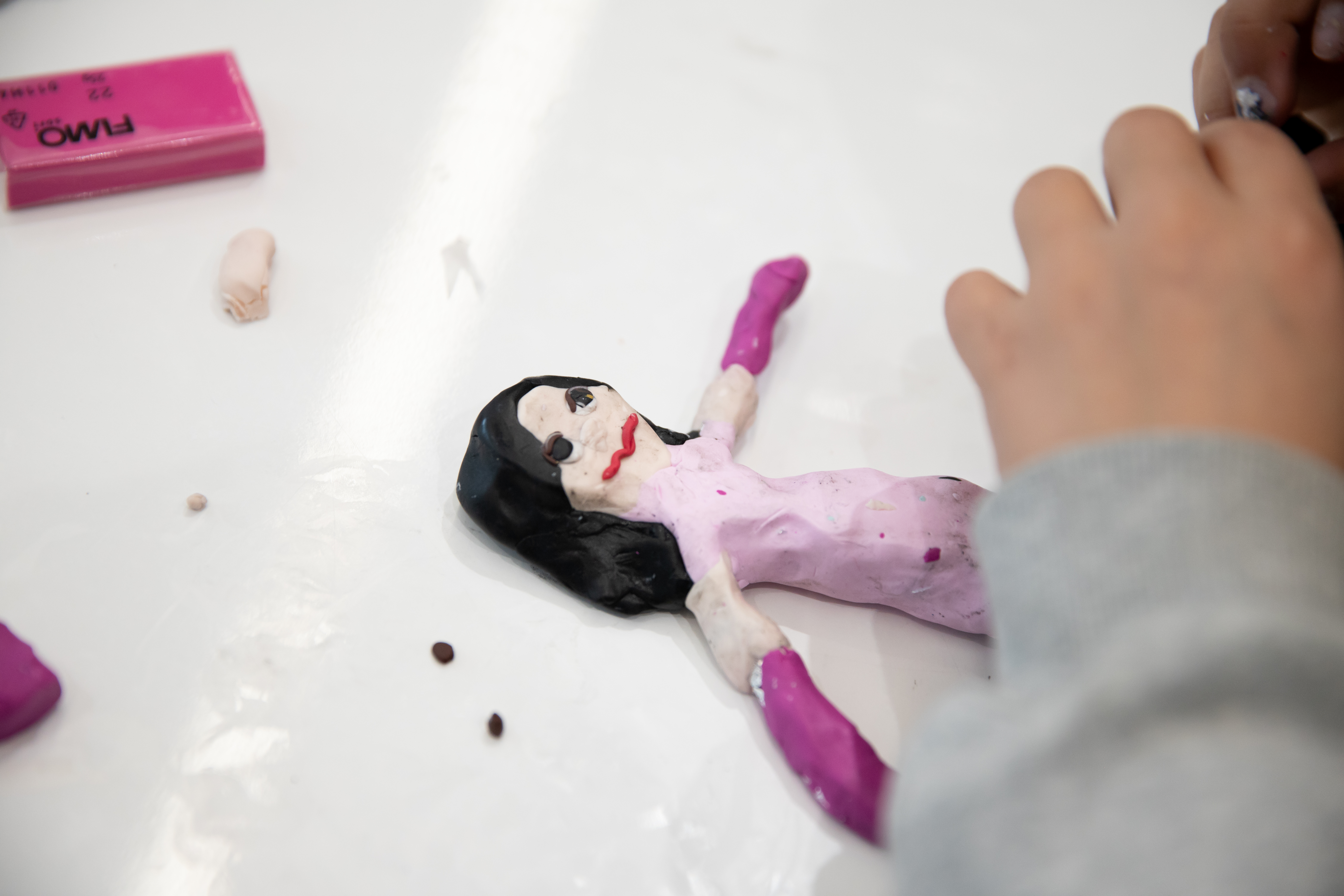 A pink puppet with hands on the right