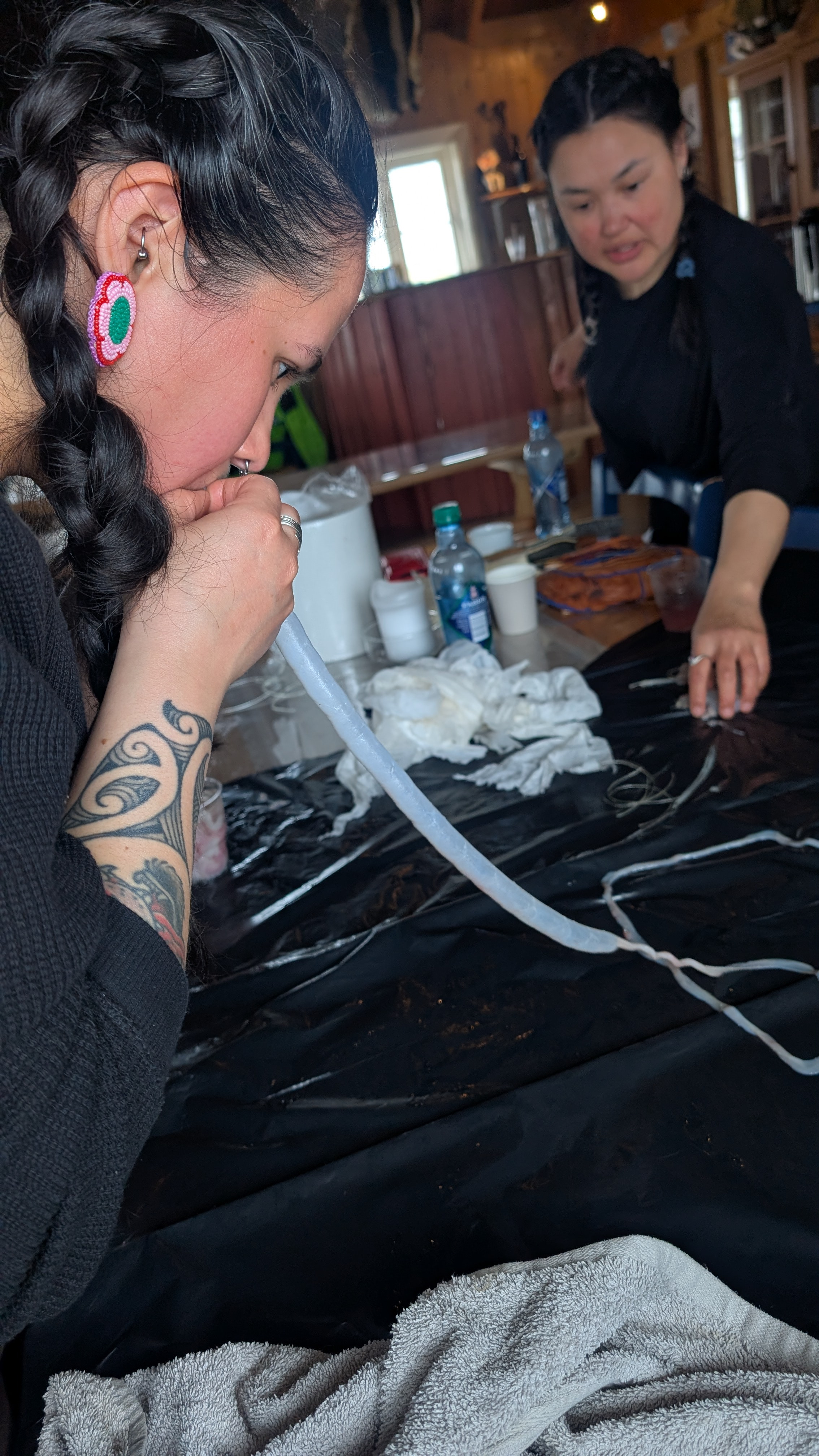A person on the left blowing up a long tan string