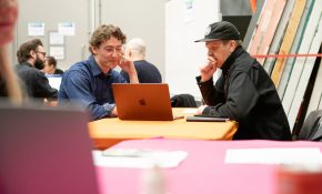A student and industry lead chat at a table with a pink tablecloth