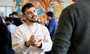 A student is using their hands animatedly to explain something at a mixer