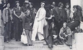 A group of fashionable students socializing on the front steps of the school in the 1970s.