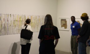 Four people in discussion in front of an artwork