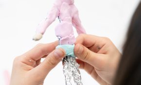 A student adding plasticine to a figure of a young girl