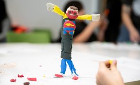 A puppet with its arms out with yellow, red, blue and