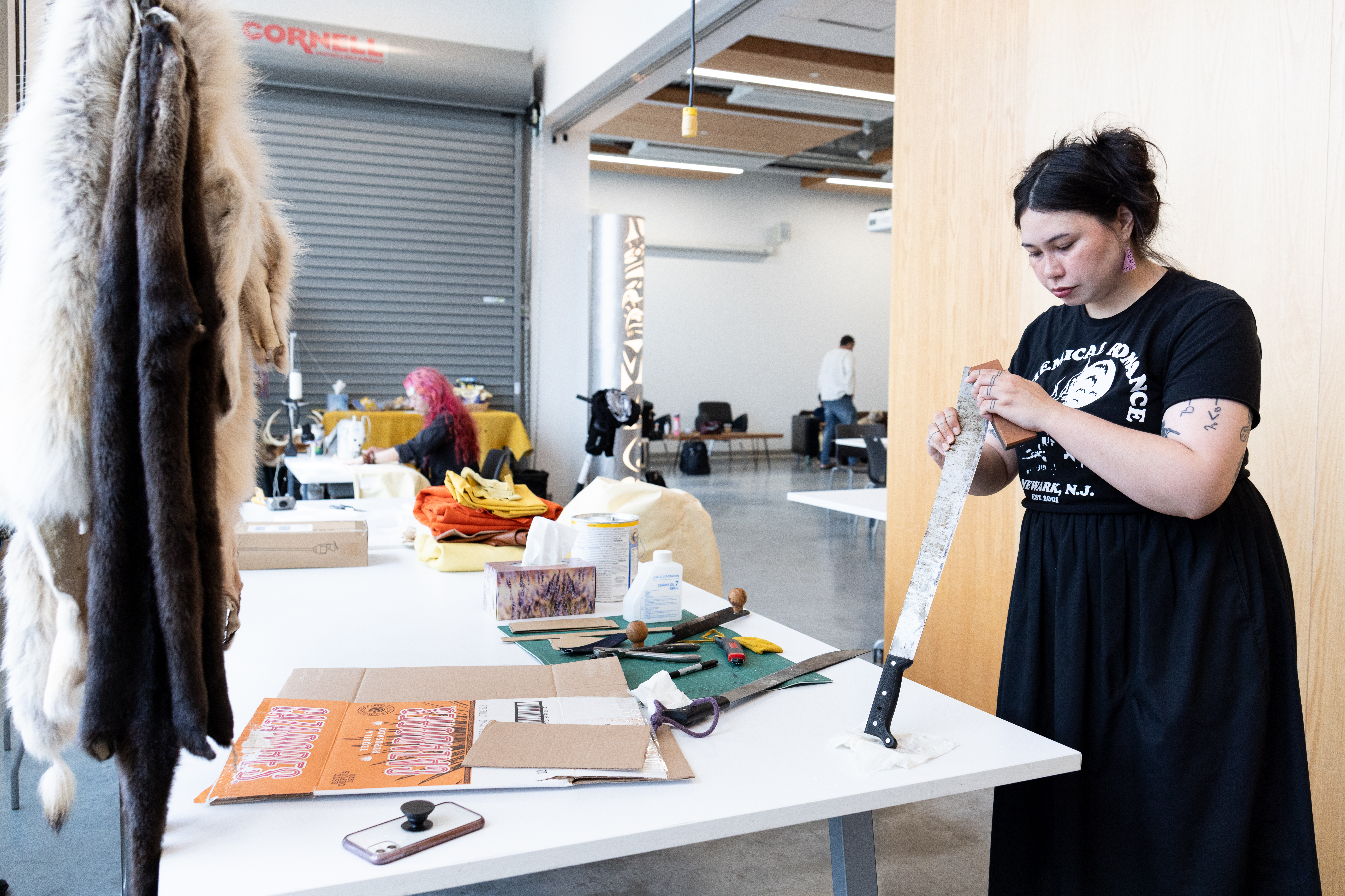 Leanne Inuarak-Dall sharpens a machete at the AGP. (Photo by Perrin Grauer)