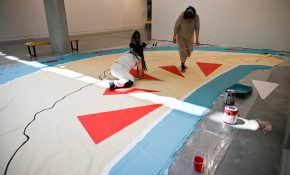 (From L): Alysha Johnny Hawkins, Isabelle Jarman and Jennifer Mitchell paint the canvas covering. (Photo by Sydney Pascal / courtesy the AGP)
