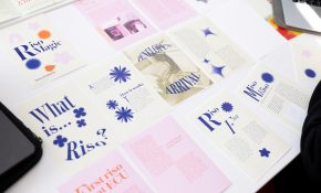 Pieces of paper bearing colourful text and graphics are spread across a table.