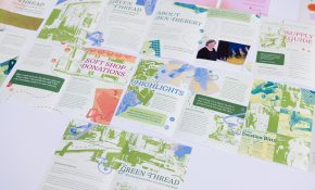 Pieces of paper bearing colourful text and graphics are spread across a table.