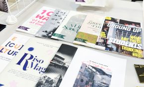 Colourful printed booklets are displayed on a table.